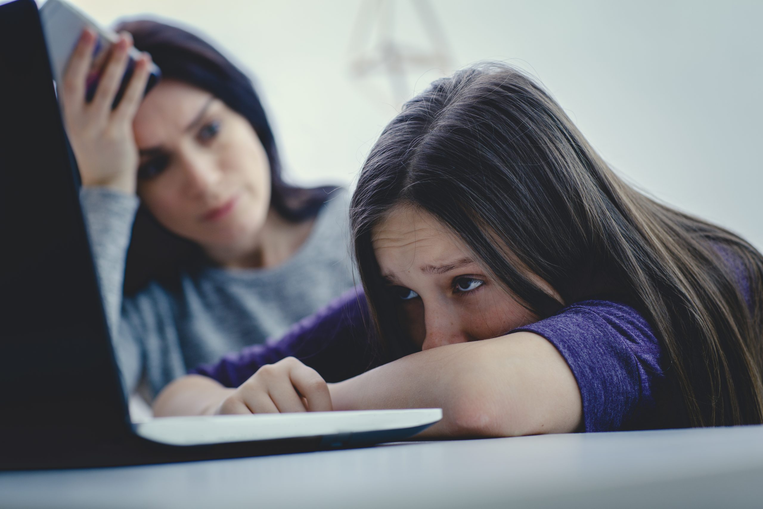 Scared mother arguing daughter over online activity. Cyber bullying or blue whale game concept