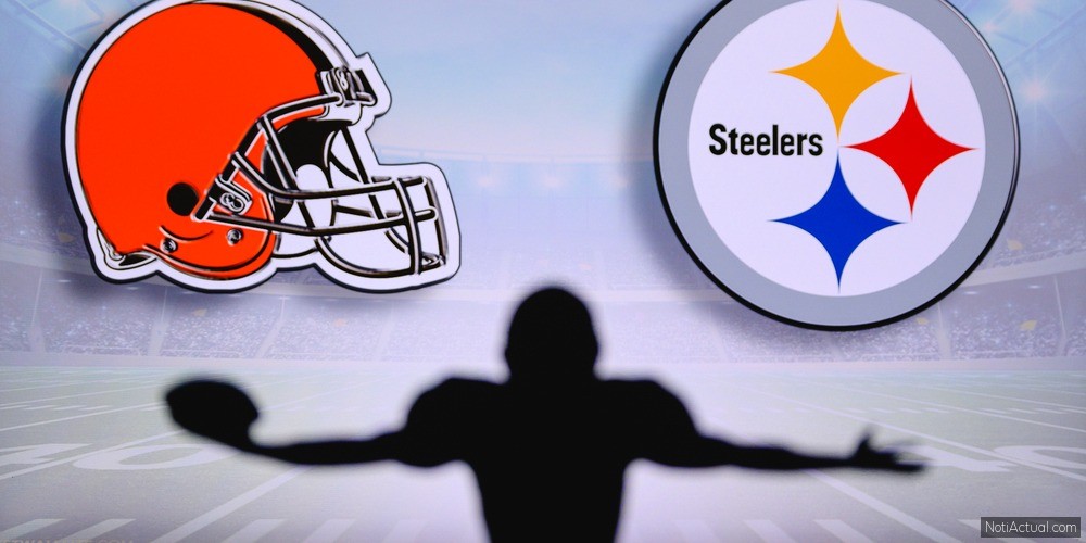 Cleveland Browns vs. Pittsburgh Steelers. NFL Game. American Football League match. Silhouette of professional player celebrate touch down. Screen in background.