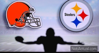 Cleveland Browns vs. Pittsburgh Steelers. NFL Game. American Football League match. Silhouette of professional player celebrate touch down. Screen in background.