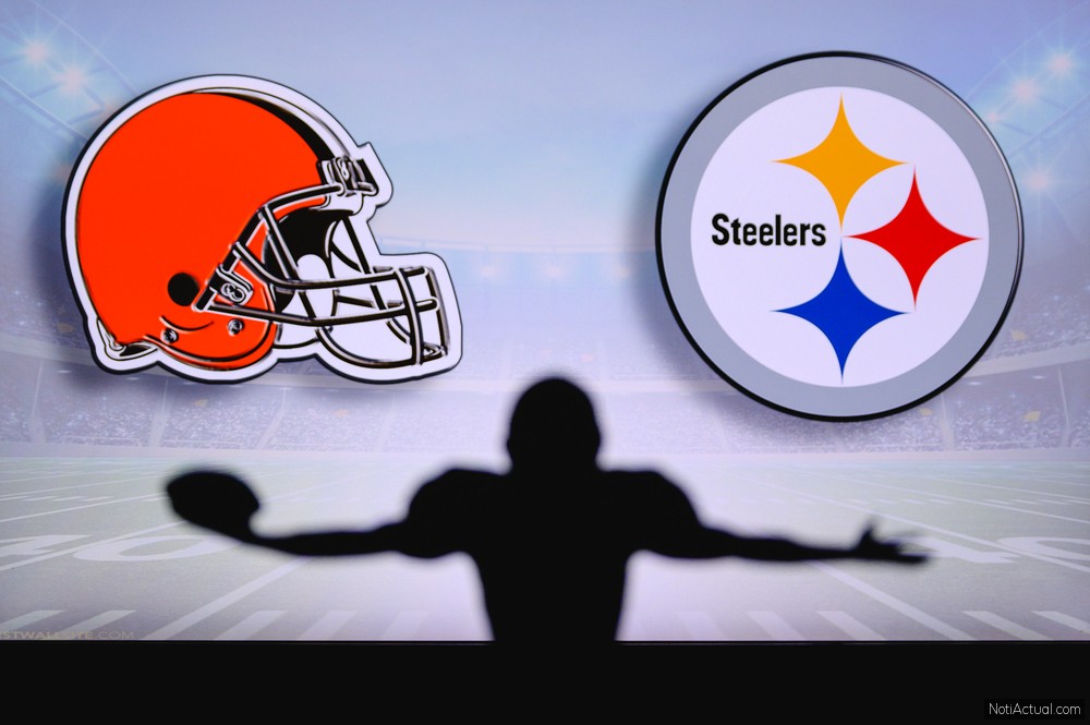 Cleveland Browns vs. Pittsburgh Steelers. NFL Game. American Football League match. Silhouette of professional player celebrate touch down. Screen in background.